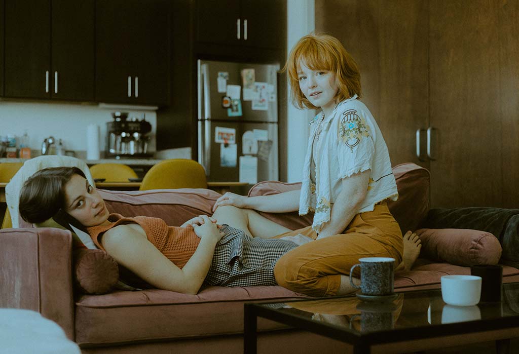 2 girls laying on couch in their home