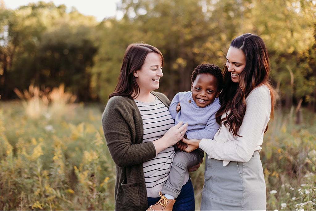 lesbian couple holding their son in a family photo