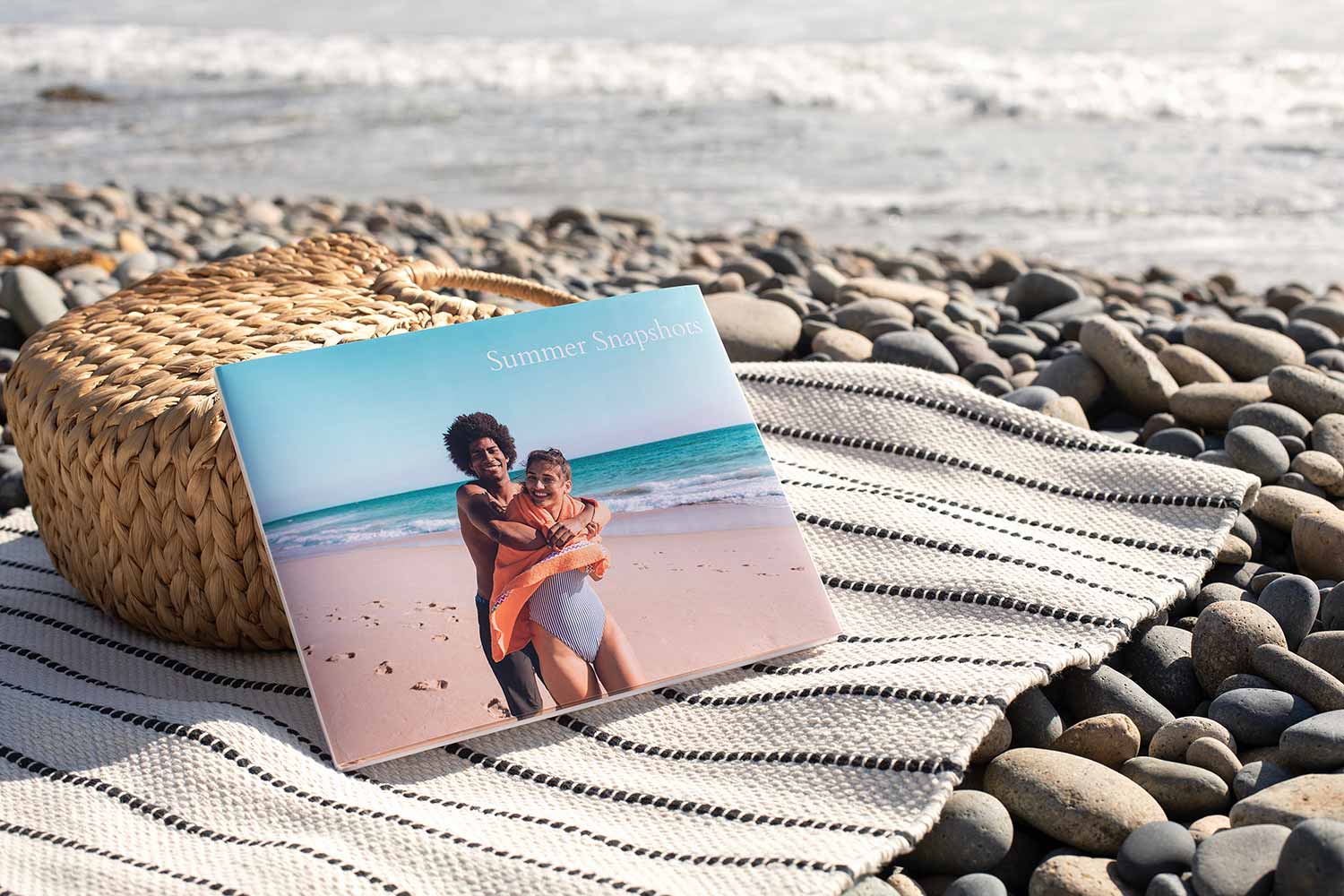 Hardcover photo book propped up on a blanket by the ocean