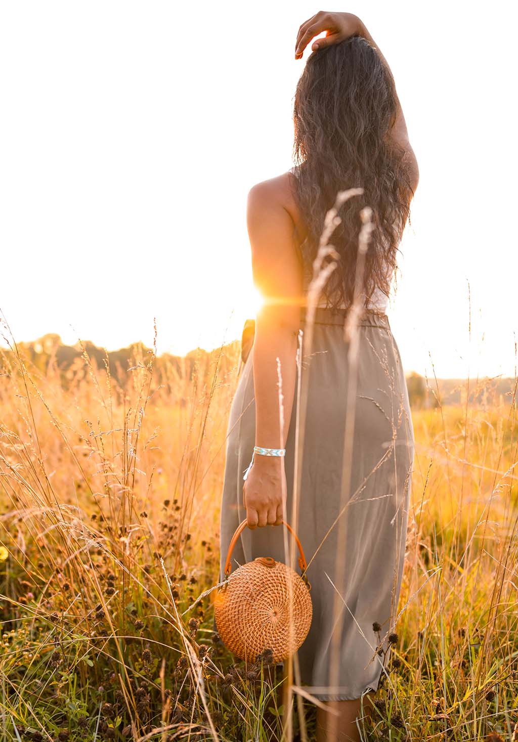 woman in field carrying a purse